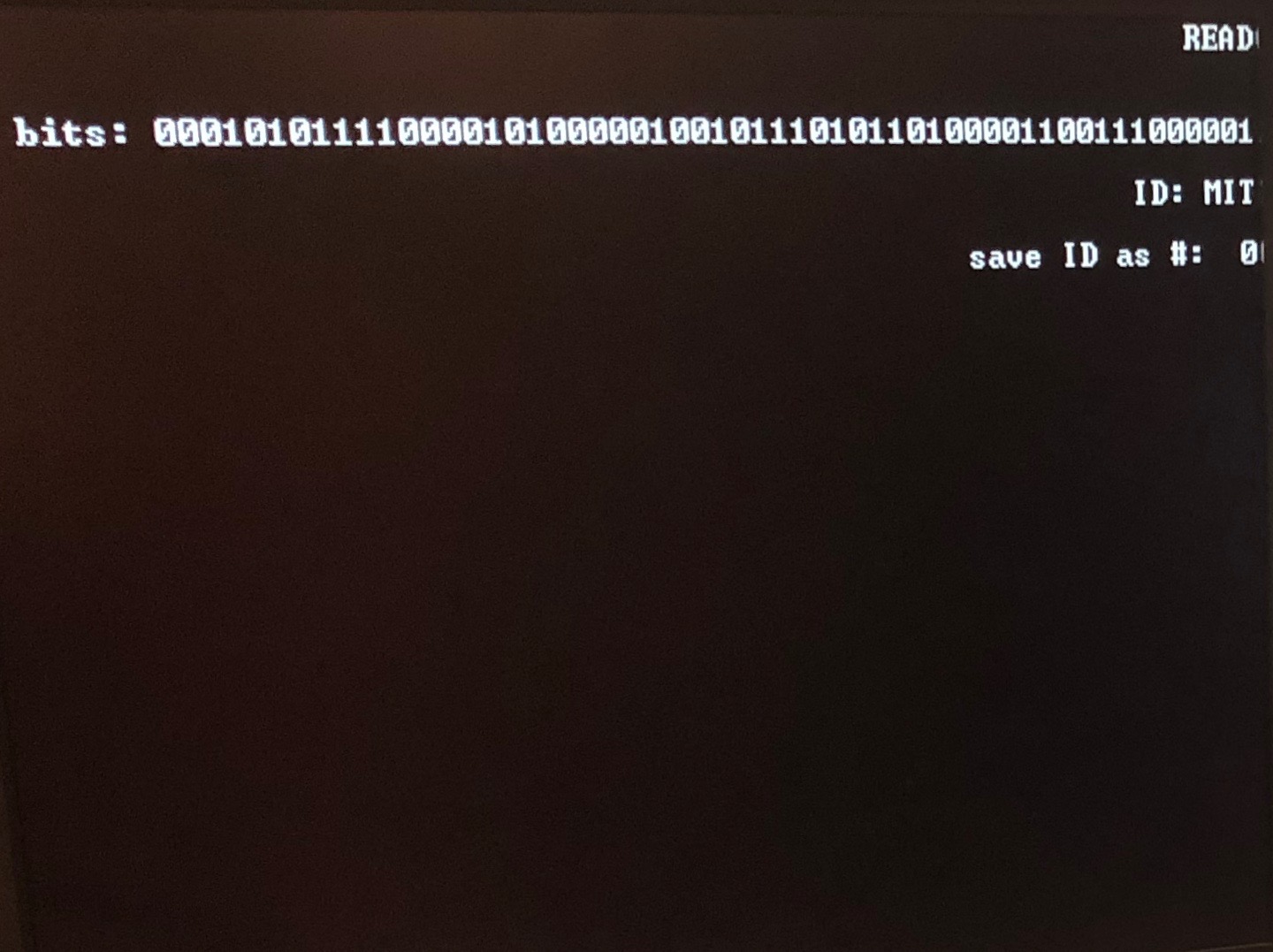 Computer monitor showing a string of bits and the words ID: MIT.