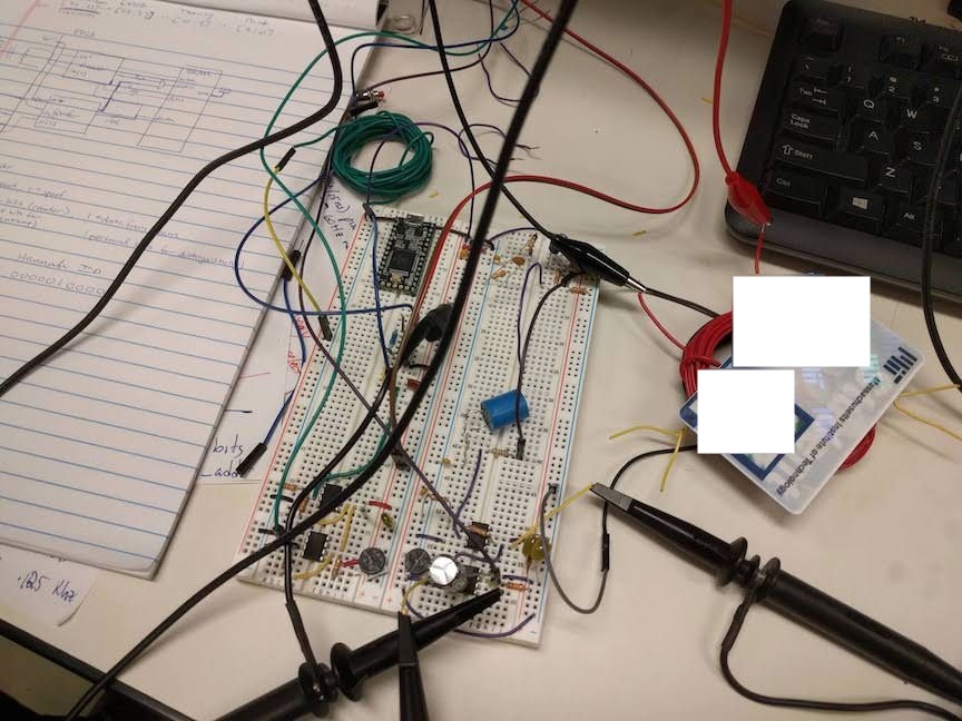 Two breadboards with an attached coil of wire. An ID card rests on top of the coil.